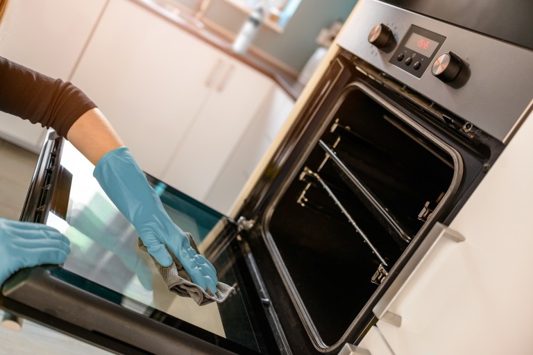 Oven with blue cleaning gloves Oven with blue cleaning gloves