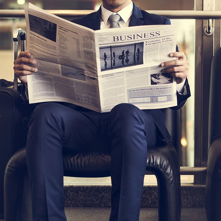 Business man sitting and reading news in a newspaper